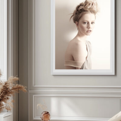 Framed fine art photograph of a woman with soft lighting and muted tones, displayed in an elegant, light-filled room.